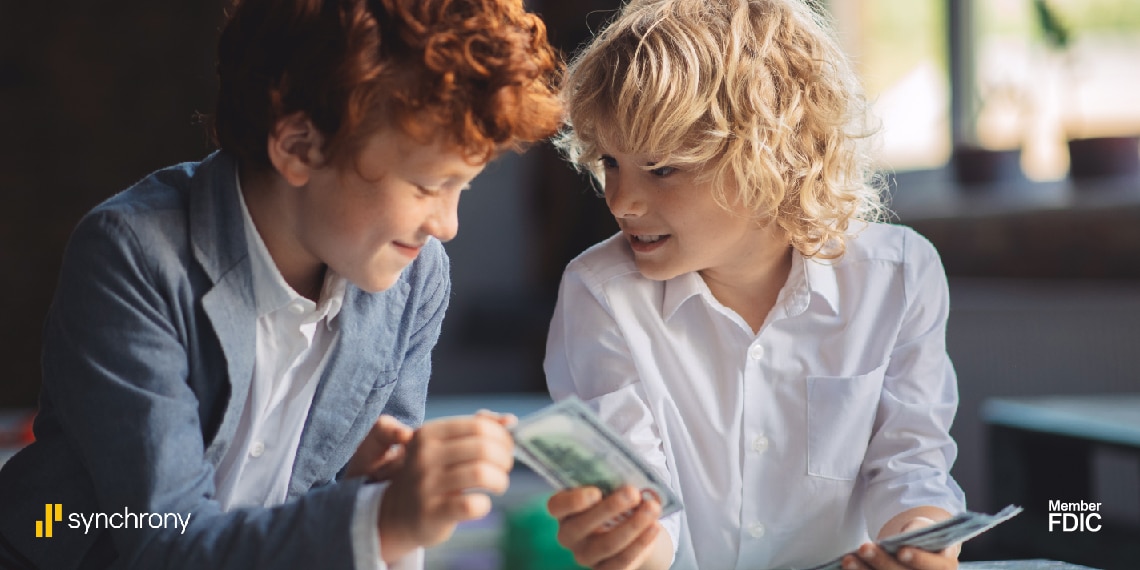 Photo of two children handling and passing money to each other.