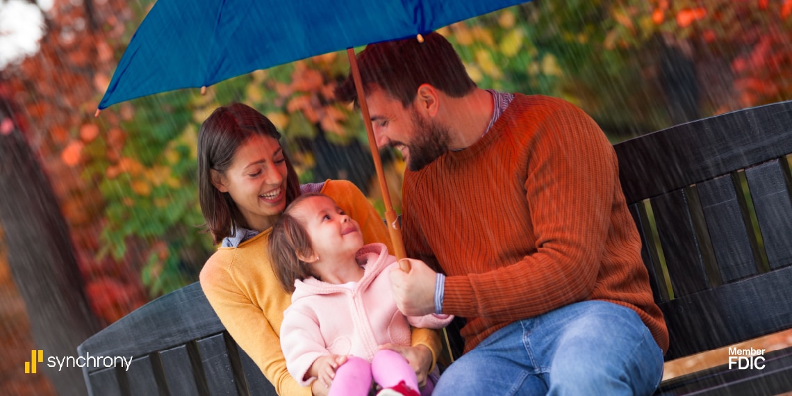 Photo of a family under a umbrella.