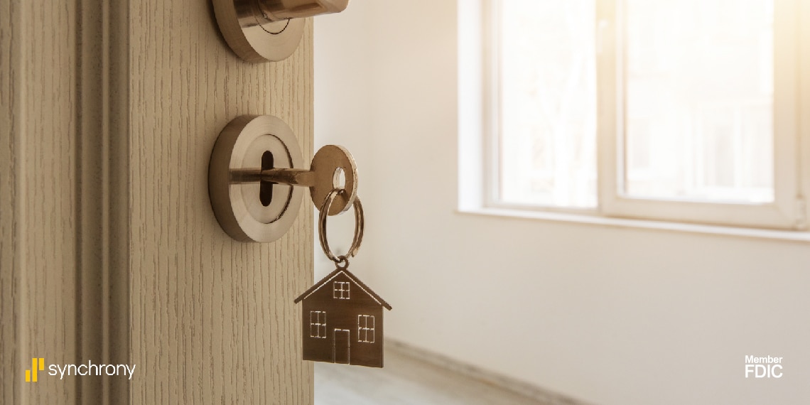 Photo of open door of home with the key in the door.