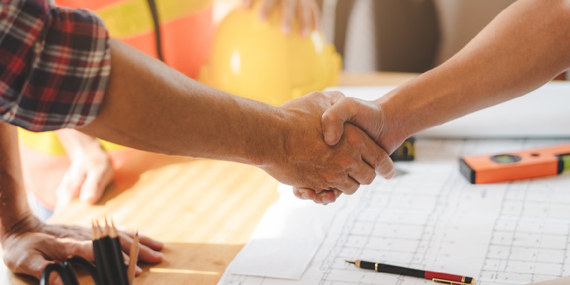 Photo of client and building contractor shaking hands in agreement.