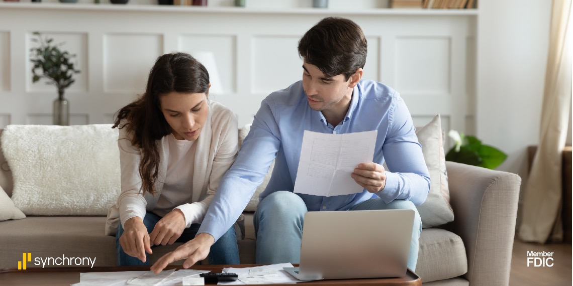 Photo of couple in home looking over a mortgage proposal.